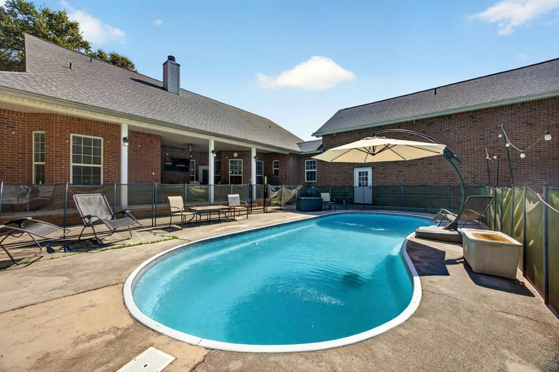Backyard pool with patio furniture and umbrella at 1735 Hagans Ridge Ct