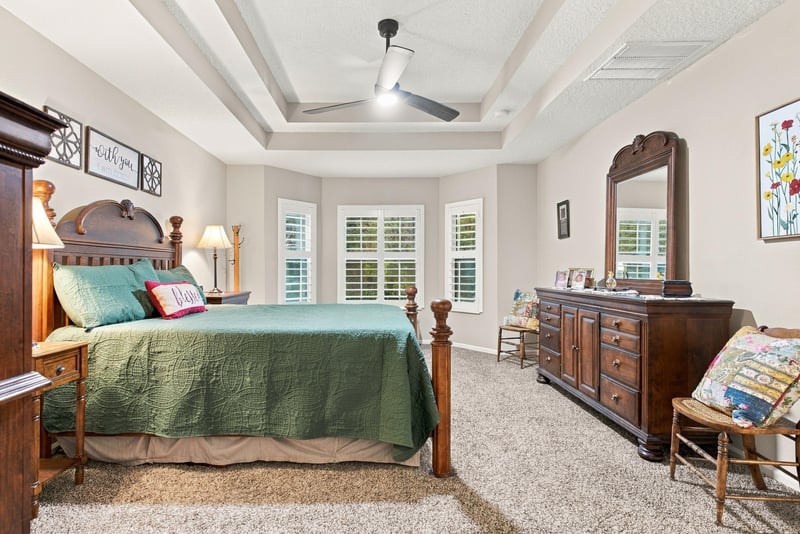 Primary bedroom with tray ceiling and four-poster bed at 10923 Black Diamond Ct, Jacksonville, FL