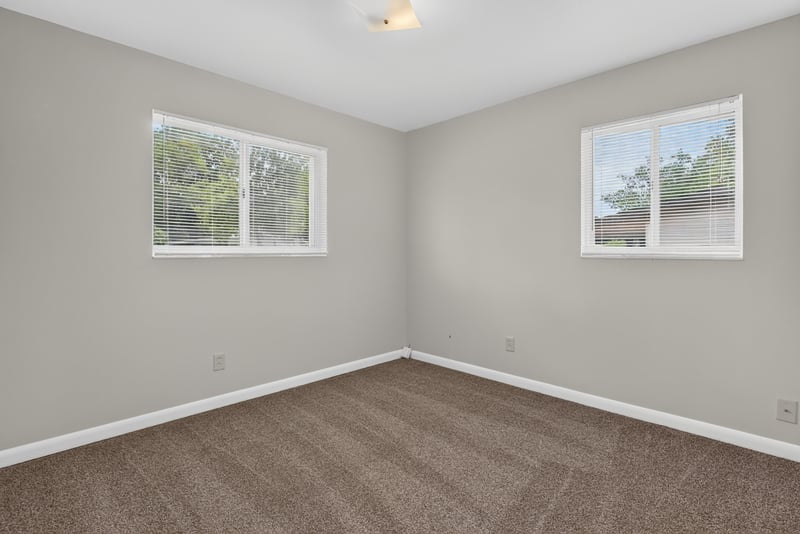 Carpeted bedroom with two windows at 2618 Arlex Dr E, Jacksonville, FL