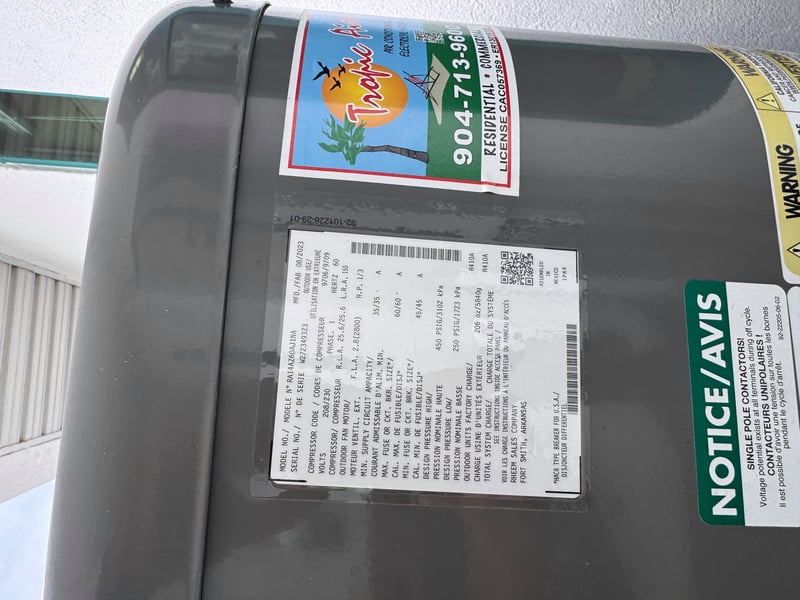 Condenser nameplate with service company phone sticker at 11700 New Kings Rd, Jacksonville, FL 32219