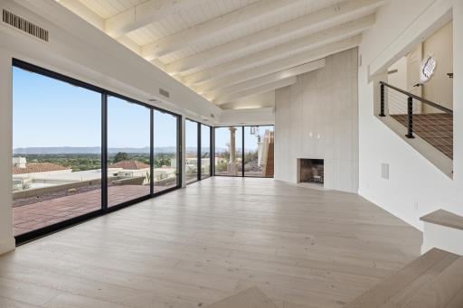 Living room with a wall of glass and the city view, empty