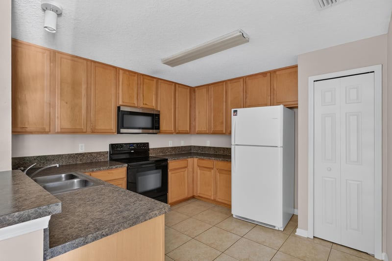 Kitchen with wood cabinets and black refrigerator at 7047 Deer Lodge Cir, Jacksonville