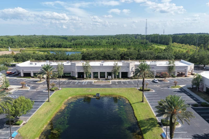 Aerial view of tree line and pond bordering the property at 10550 Deerwood Park Blvd, Jacksonville, FL 32256
