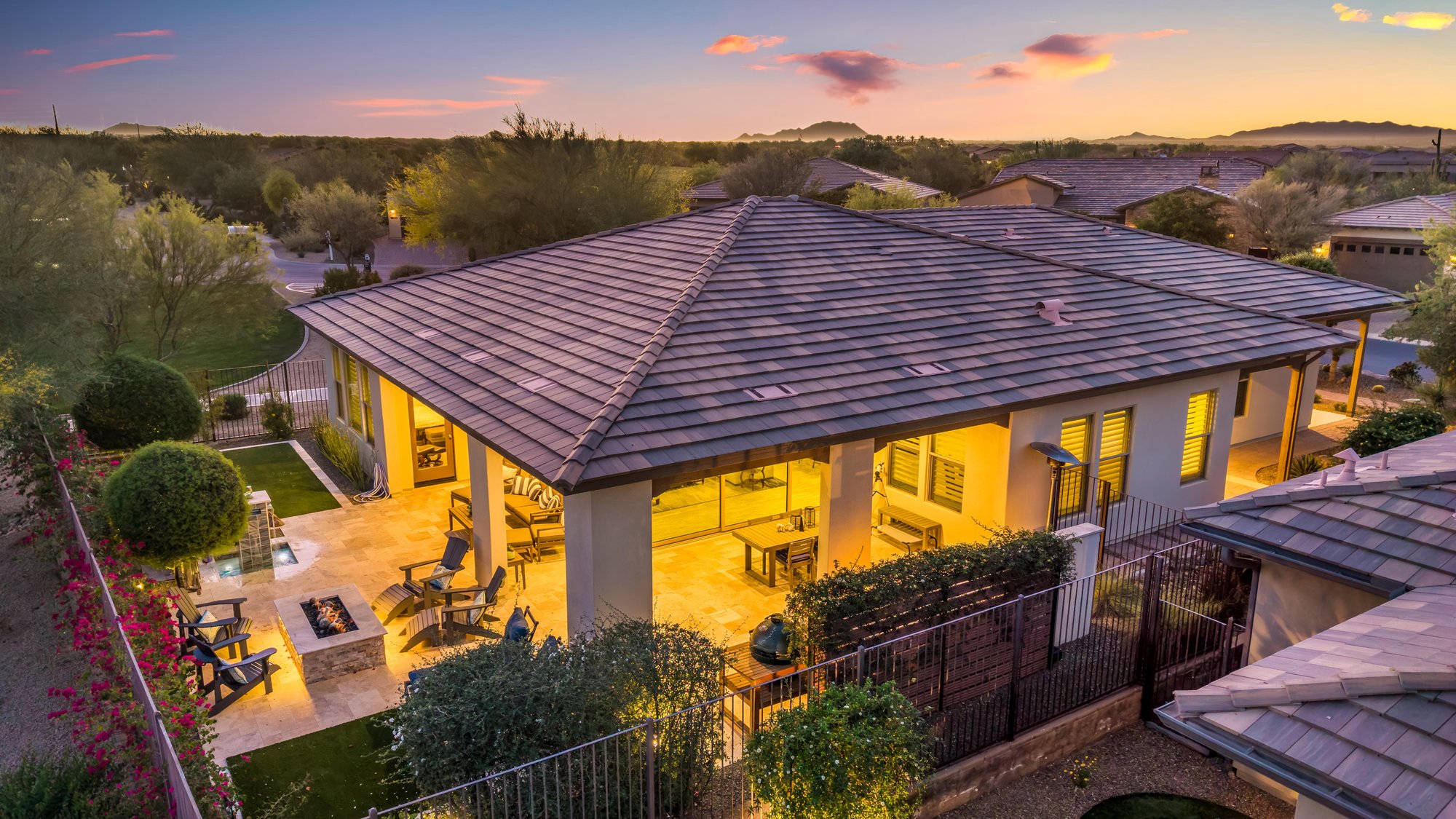 Aerial of a lit covered patio and backyard at dusk