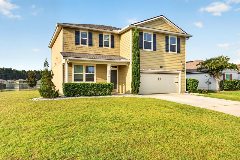Front exterior with two-car garage and landscaped lawn at 6830 Hanford St, Jacksonville, FL 32219
