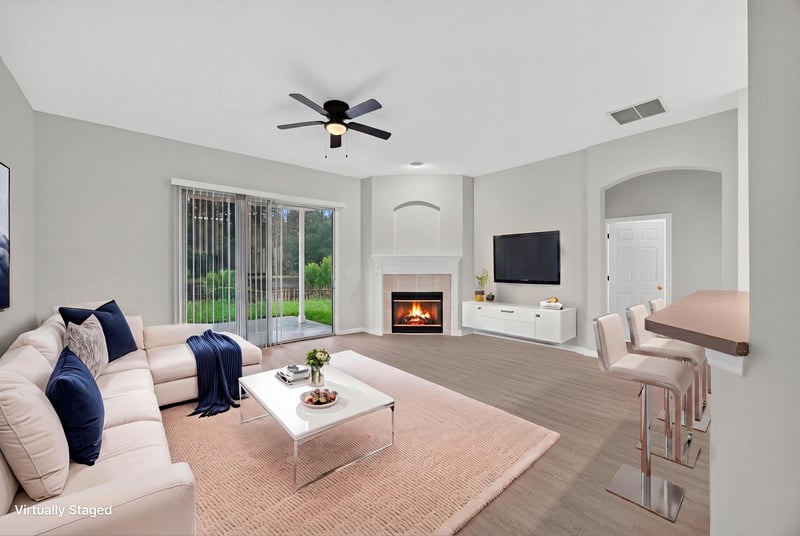 Virtually staged living room with fireplace and sofa at 706 Bonaparte Dr, Jacksonville, FL 32218