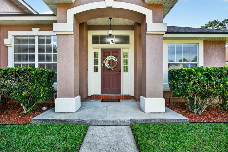Front entry door with wreath and columned porch at 3112 Silverado Cir, Green Cove Springs, FL 32043