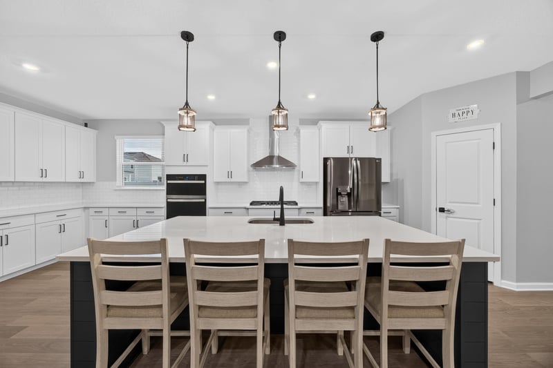 Kitchen island with seating and white cabinetry at 2354 Jennings Farm Dr, Middleburg, FL 32068