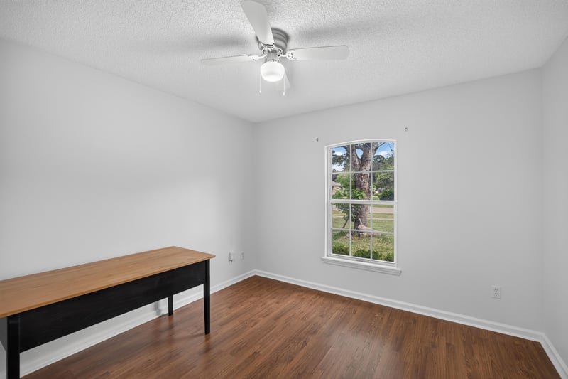 Bedroom with wood floors and bench at 9691 Nelson Forks Dr, Jacksonville, FL 32222