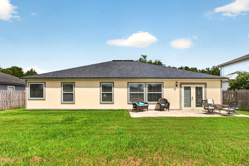 Back exterior with covered patio and open lawn at 2065 Creekmont Dr