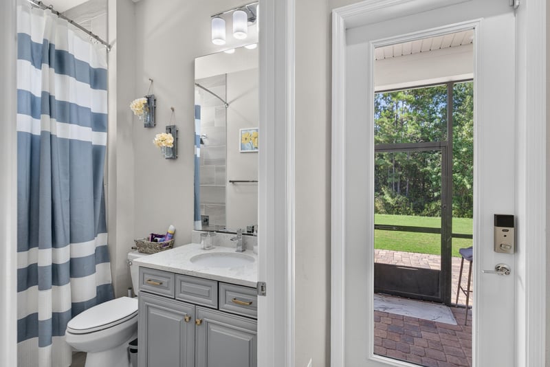 Bathroom with vanity and door to exterior at 22 Azura Point