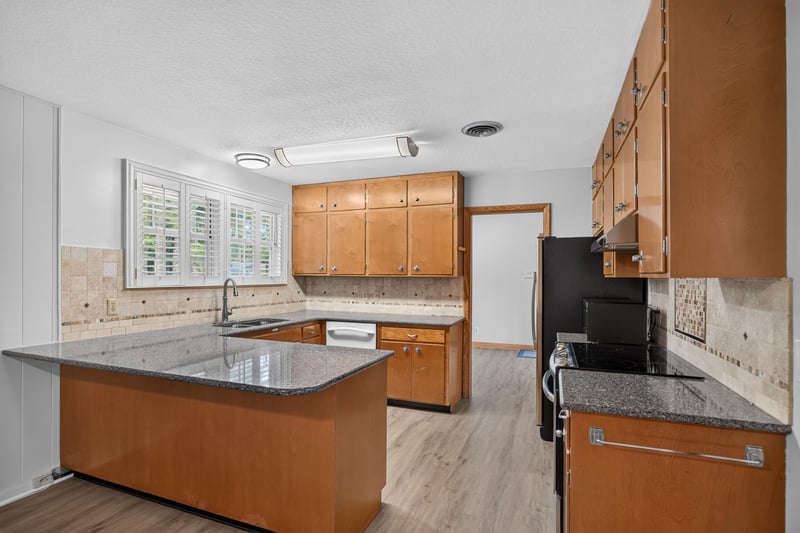 Kitchen with wood cabinets, granite counters and peninsula at 1834 Memory Ln, Jacksonville, FL