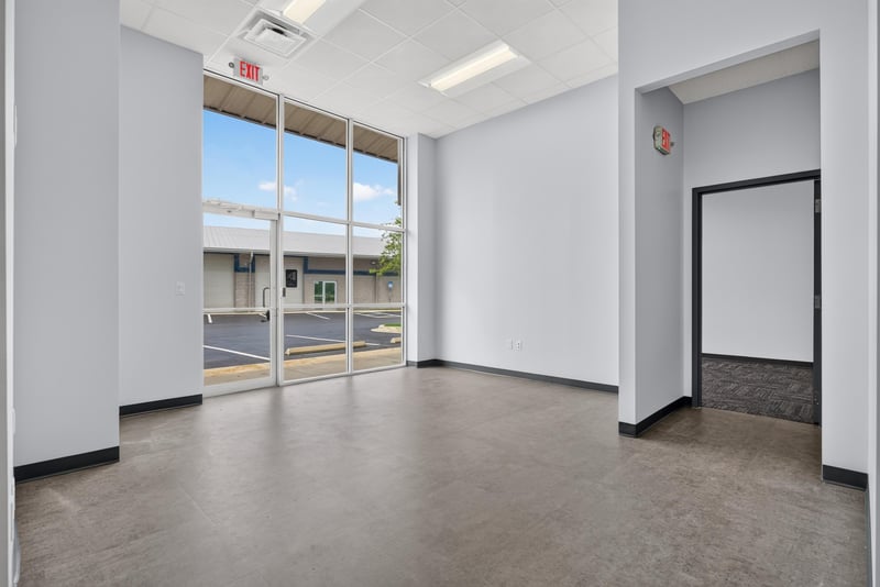 Open commercial space with glass storefront doors and overhead lighting at 7240 Golden Wings Rd building 100, Jacksonville, FL 32244