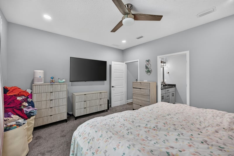 Primary bedroom with television and dresser at 2817 Camel Cir, Middleburg, FL