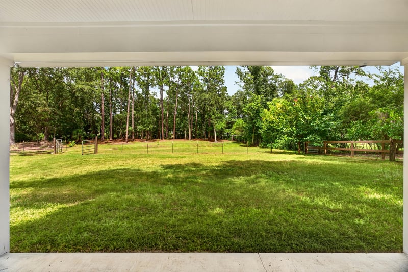 Backyard view of open lawn and trees at 1161 Whispering Pines Rd, Jacksonville, FL 32259