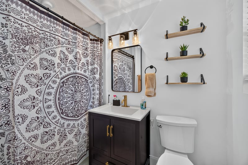 Bathroom with patterned accent wall and vanity at 6059 Karen St, Jacksonville, FL 32244
