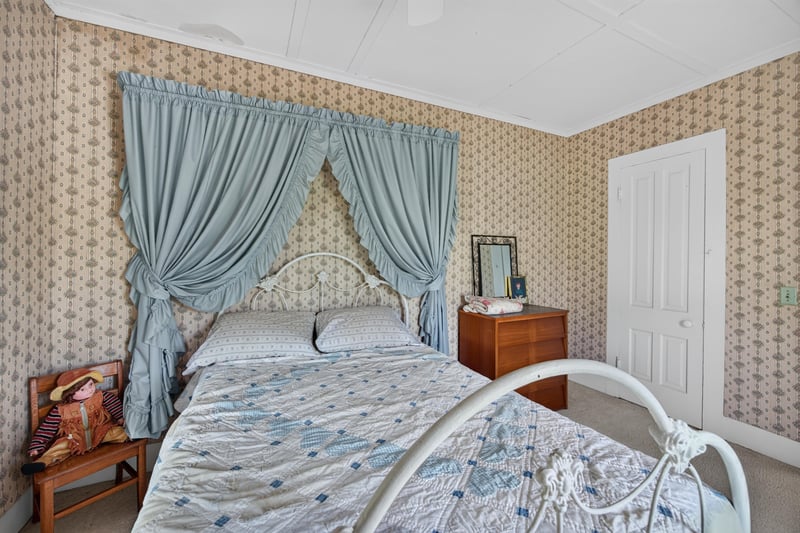 Bedroom with wallpaper and upholstered bed at 1173 US-17, Satsuma, FL 32189