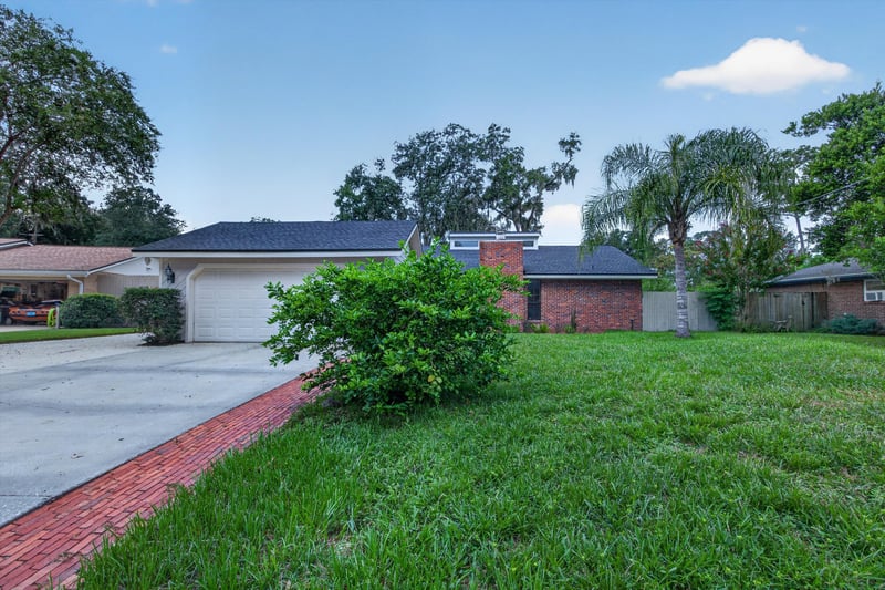 Front exterior with driveway and brick walkway at 12344 Cormorant Ct, Jacksonville, FL