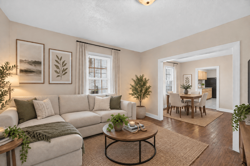 Virtually staged living room with sofa and dining area beyond at 1473 State St W, Jacksonville, FL 32209