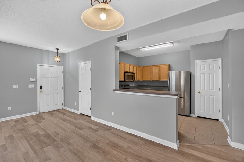 Kitchen entry with range hood and wood-look floor at 575 Oakleaf Plantation Pkwy, Orange Park, FL 32065