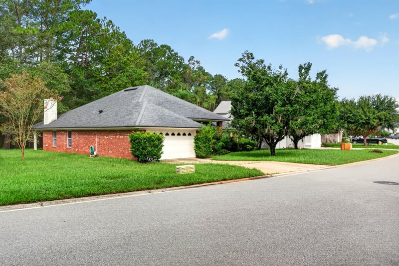Front exterior view with garage door and landscaping at 11669 Collins Creek Dr, Jacksonville, FL 32258