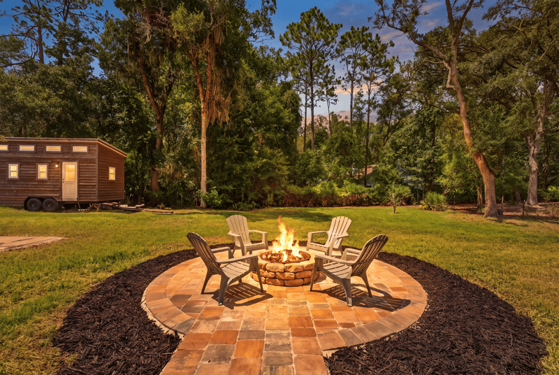 Fire pit seating area with lawn and trees at 1161 Whispering Pines Rd, Jacksonville, FL 32259