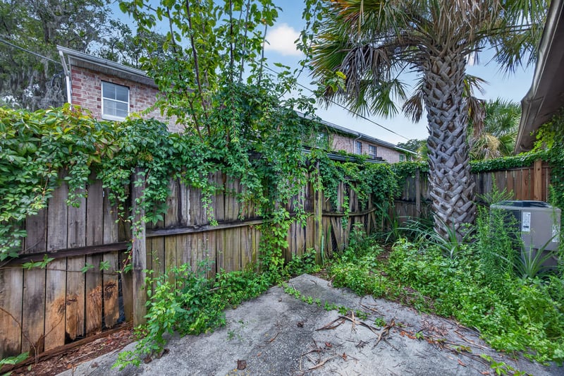 Back yard with palm tree and wood fence at day-to-dusk at 2719 Trollie Ln