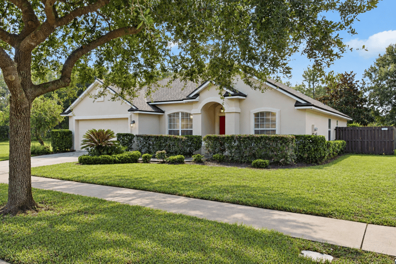 Front exterior framed by a mature oak tree at 14187 Big Spring St, Jacksonville, FL 32258