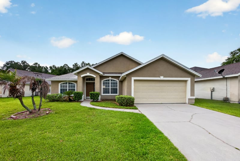 Front exterior with tile roof and palm trees at 706 Bonaparte Dr, Jacksonville, FL 32218