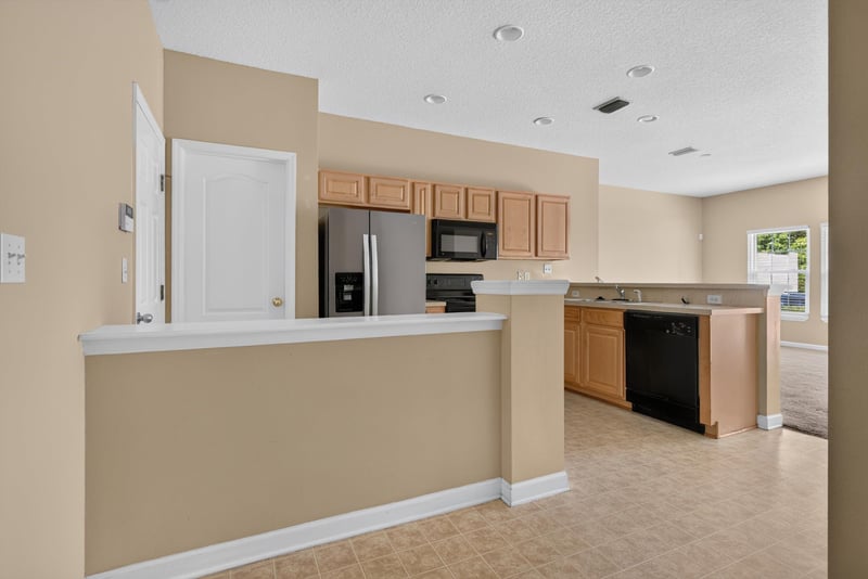 Kitchen peninsula with black appliances at 12359 Mangrove Forest Ct, Jacksonville, FL 32218