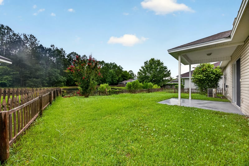 Backyard with fenced yard and mature trees at 706 Bonaparte Dr, Jacksonville, FL 32218