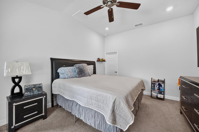 Primary bedroom with wood bed frame and carpet at 9846 Olivia St, Jacksonville, FL