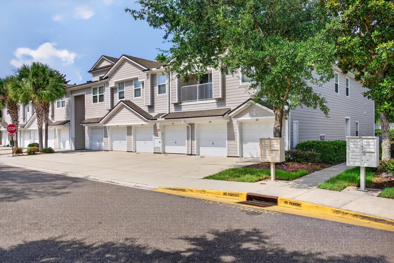 Street view of the front exterior with palm trees at 8196 Cabin Lake Cir, Jacksonville, FL 32256