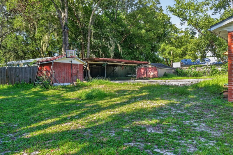 Backyard with shed and shaded trees at 5745 110th St, Jacksonville, FL 32244