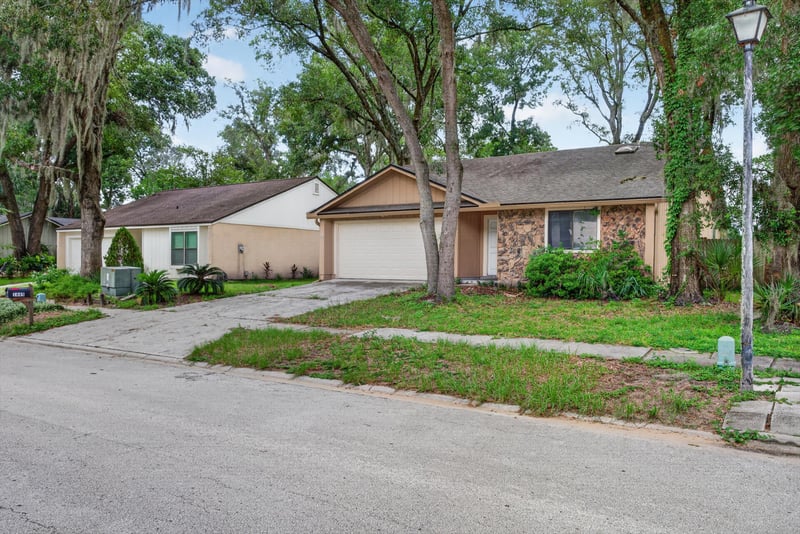 Street view of home among oak trees at 1445 Classic Oak Rd W, Jacksonville, FL