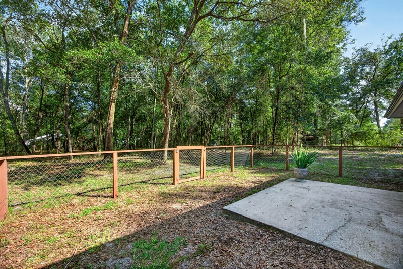 Fenced yard area with wooded surroundings at 2829 Blackberry Ave