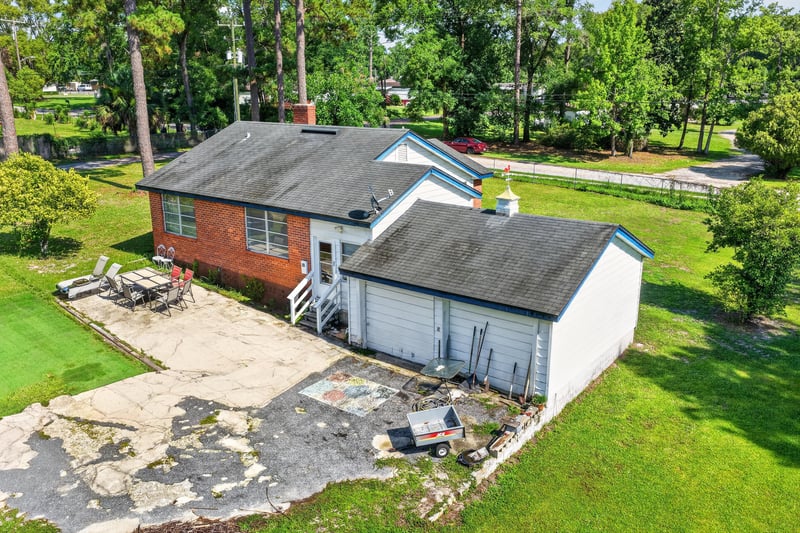 Side exterior with carport and debris pile at 5745 110th St, Jacksonville, FL 32244
