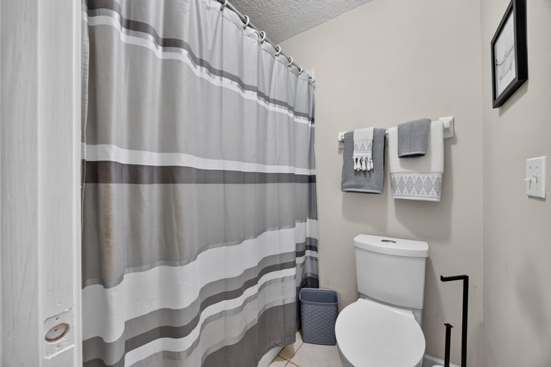Bathroom with striped shower curtain and tub at 3067 Wavering Ln, Middleburg, FL 32068