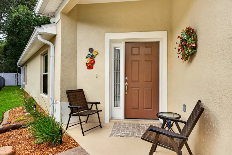 Front door with wreath and seating area at 11225 Water Spring Cir, Jacksonville, FL 32256
