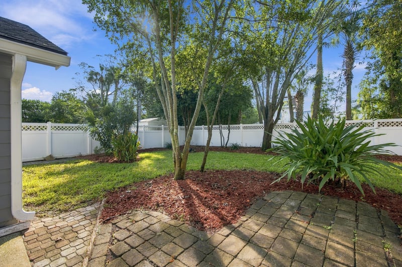 Backyard with brick patio and landscaping at 678 5th Ave N, Jacksonville Beach, FL 32250