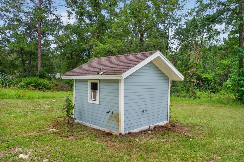 White storage shed surrounded by trees at 4890 McAllister Rd, Middleburg, FL 32068