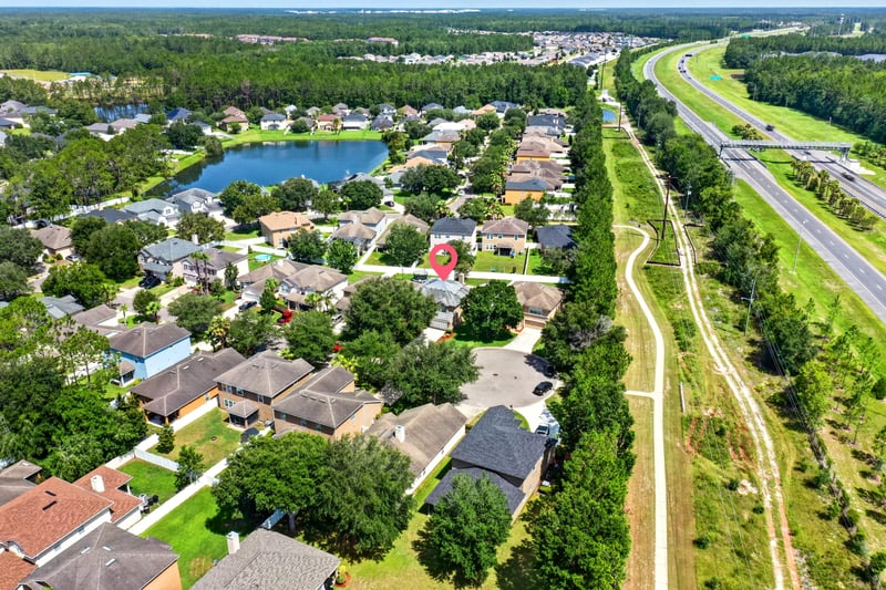 Aerial view of the neighborhood with pond and road in Orange Park, FL