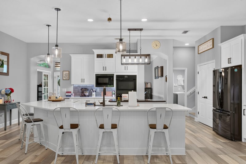 Kitchen island with stools and pendant lights at 2304 Spring Hill Ct, Orange Park, FL