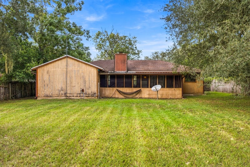 Rear exterior of home with chimney and screened porch at 2915 Trenton Ct, Orange Park, FL