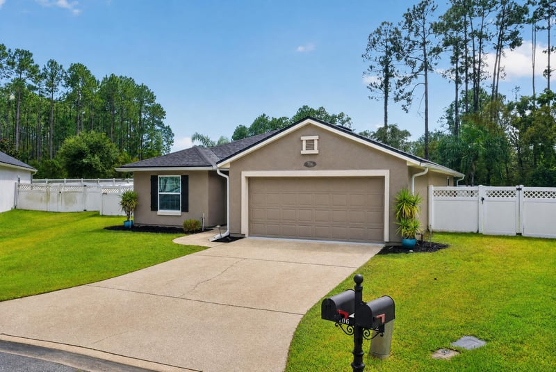 Front exterior with three-car garage at 706 Grampian Highlands Dr, St. Johns, FL 32259