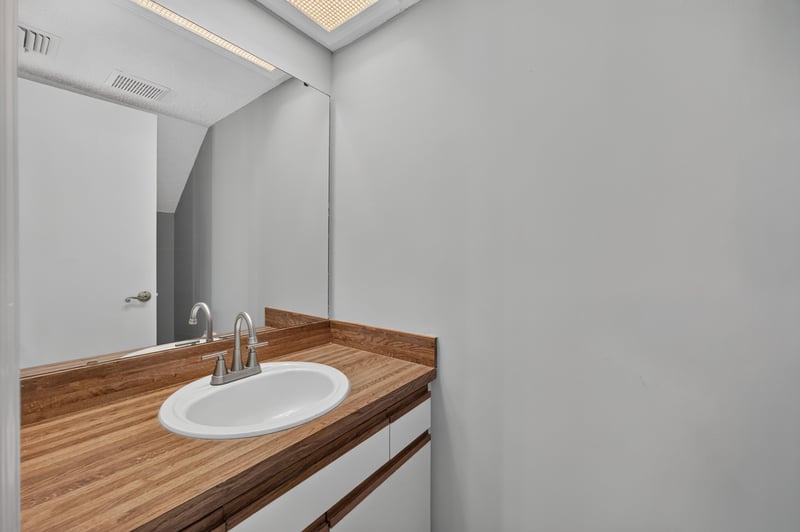 Bathroom vanity with butcher block counter and mirror at 3801 Crown Point Rd, Jacksonville, FL 32257