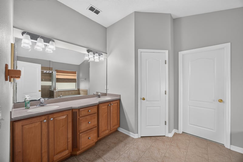 Bathroom with double-sink vanity and wood cabinets at 635 Wakeview Dr, Orange Park, FL 32065