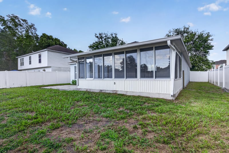 Rear exterior with screened porch and fenced yard at 1845 Saga Ct, Middleburg, FL
