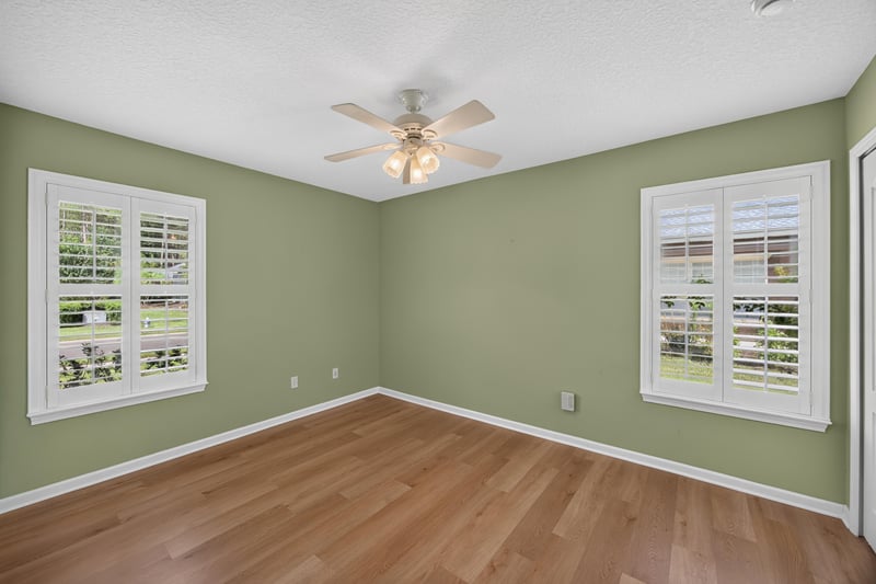 Bedroom with green walls and wood floors at 2131 E Stone Creek Dr, Fleming Island, FL