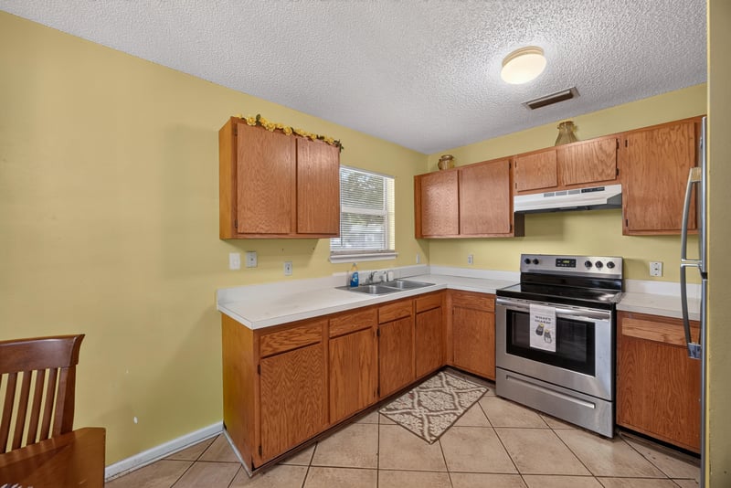 Kitchen with wood cabinets and gas range at 5375 Dodge Rd, Jacksonville, FL 32209